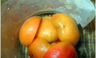 Cum să gătești caise fără să gătești cu zahăr pentru iarnă? Spalam fructele sub apa, le impartim in jumatati si scoatem semintele. Puneți caisele pregătite în primul strat în borcane sterile.
