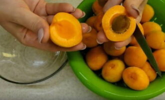 Com preparar una preparació d'albercoc saborosa i senzilla per a l'hivern? Trieu les fruites, traieu-ne les danyades, esbandiu amb aigua corrent, talleu-les a la meitat amb un ganivet afilat i traieu les llavors.