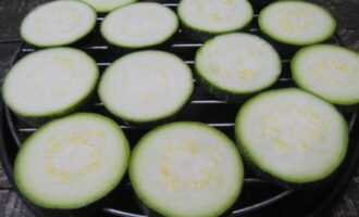 Upang maghurno ng zucchini casserole na may keso at mga kamatis sa oven, hugasan muna ang zucchini at gupitin ito sa mga bilog na pantay na kapal. Ilagay ang mga ito sa isang wire rack at maghurno sa oven na preheated sa 200 degrees sa loob ng 20 minuto.