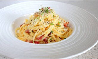 Hatiin ang carbonara pasta na may bacon na inihanda ayon sa klasikong recipe sa mga serving bowl, budburan ng sariwang giniling na paminta at ihain nang mainit. Bon appetit!