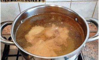 Cho thịt lợn vào nồi, thêm nước và nấu trong một tiếng rưỡi kể từ khi sôi, định kỳ loại bỏ bọt bằng thìa có rãnh.