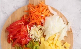 Vi rengör och skär grönsakerna i remsor (sötpepparmassa, morötter, vitlök och tomater), potatis i tärningar, syrablad i stora bitar. Finhacka salladslökens fjädrar och syrliga stjälkar.