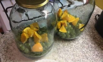 Plaats de bessen en plakjes sinaasappel op de bodem van een steriele pot.