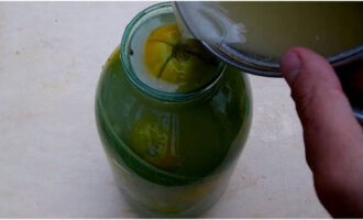 Turnați saramura pregătită peste roșiile din borcan, așteptați puțin și apoi adăugați restul de saramură chiar deasupra.