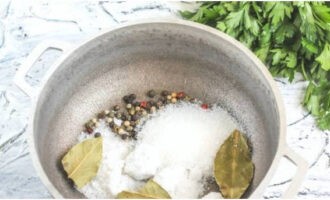 Giet zout en kristalsuiker in een pan, voeg peperkorrels en laurierblaadjes toe.