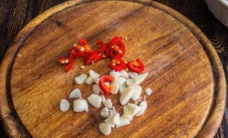 Bóc vỏ tỏi và cắt thành miếng. Chúng ta cũng cắt ớt đã rửa sạch thành từng miếng nhỏ.