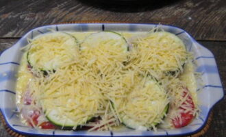 Takpan muli ng mga hiwa ng zucchini. Ibuhos ang sarsa at takpan ng grated cheese.