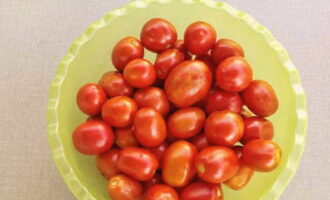 Om tomaten met uien en plantaardige olie voor de winter klaar te maken, lik je je vingers af en meet je het benodigde aantal tomaten af. We wassen ze onder water en verwijderen de stengels.