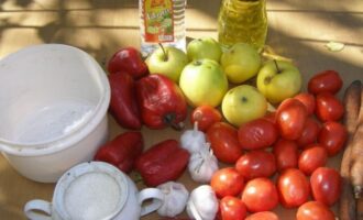 Om adjika met appels en tomaten voor de winter te bereiden, meet u de benodigde hoeveelheid groenten af, spoelt u elk fruit grondig onder stromend water en laat u het even drogen.