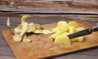 Intre timp, curatati cartofii si taiati-i bucatele. Scoateți stratul superior de ceapă și tăiați-l. Se caleste intr-o cantitate mica de ulei vegetal.
