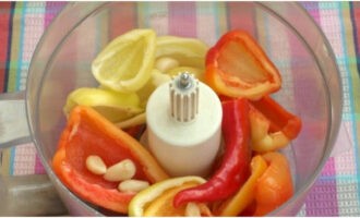 Doe het vruchtvlees van de paprika, evenals de hete peper en de gepelde knoflook in de kom van een blender of keukenmachine en klop.