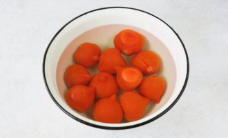 Vi gör grunda snitt på de förberedda tomaterna och skållar dem med kokande vatten.