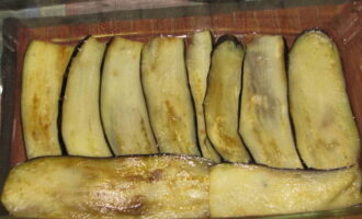 Bak de aubergines in een verwarmde koekenpan in plantaardige olie gedurende twee minuten aan elke kant. Plaats ze vervolgens in een ovenschaal.