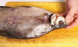 Nagsisimula kaming linisin ang isda sa pamamagitan ng pagputol ng mga hasang.