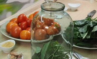 Op de bodem van de pot plaatsen we mierikswortelbladeren en kersen- of bessenbladeren, paraplu's van aromatische dille en peperkorrels. 