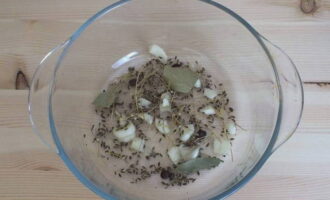 Doe twee kleine parasolletjes dille, gehakt laurierblad en gehakt teentje knoflook met piment in een beitskom.