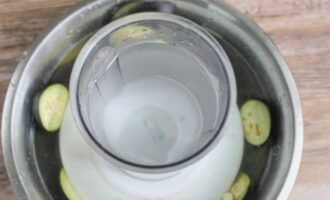 Ibuhos ang kumukulong tubig sa mga hiniwang talong. Maglagay ng plato na may anumang timbang sa itaas at mag-iwan ng 25 minuto.