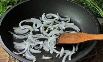 Cắt hành tây thành nửa vòng.Chiên nó trong vài phút trong dầu thực vật.