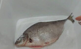 Pagpili ng angkop na lalagyan para sa pag-aasin ng isda. Ibuhos ang asin sa ilalim at ilagay ang isda.