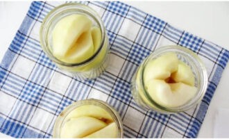 Umpleți bine borcanele sterile cu felii de fructe.