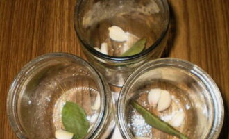 Wij steriliseren potten. Doe er knoflookteentjes, krentenblaadjes en kruiden in.