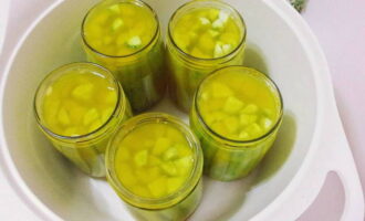 Ipamahagi ang kumukulong marinade sa mga paghahanda at takpan ng sterile lids. Ilipat sa isang sterilization pan, ang ilalim nito ay natatakpan ng tuwalya. Punan ng tubig at pakuluan ng 5 minuto, tandaan ang oras mula sa pagkulo.Tinatakan namin ang mga mainit na garapon, hawak ang mga ito ng oven mitt para sa kaligtasan.