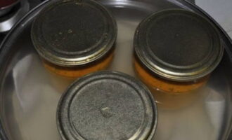 Giet het mengsel in steriele potten. Dek de stukken af ​​met deksels en doe ze in een grote pan met water. Zorg ervoor dat u een handdoek op de bodem legt. We steriliseren gevulde potten na kokend water - literpotten gedurende 30 minuten, potten van een halve liter - 20 minuten.