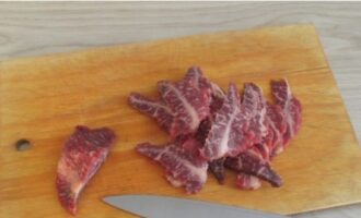 Skär det frysta nötköttet i tunna skivor och stek i uppvärmd vegetabilisk olja, lägg bitarna i ett lager.