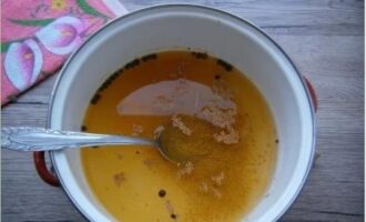 Om de marinade te bereiden, giet je azijn in een pan en voeg je kruiden toe.