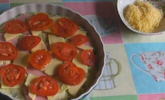 Verdeel de gesneden worst, mozzarella en tomaten gelijkmatig over het deeg. Zet de oven aan op 180°C. Bak de pizza gedurende 25 minuten. Bestrooi het vervolgens met geraspte kaas en bak nog eens 5 minuten tot de kaas smelt.