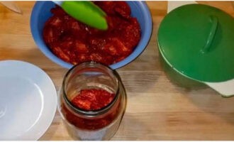 A continuació, col·loqueu les rodanxes de tomàquet sec al sol força ajustades als pots.
