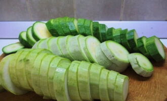Zucchini med majonnäs och vitlök i en stekpanna tillagas snabbt och enkelt. Vi tvättar zucchinin och skär dem i skivor.