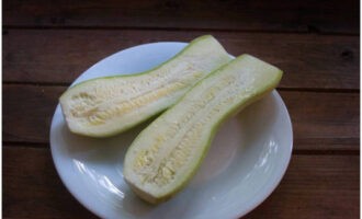 Zucchini med köttfärs och ost i ugnen är väldigt lätt att tillaga. Vi skär den tvättade zucchinin på längden, trimma svansarna på båda sidor.