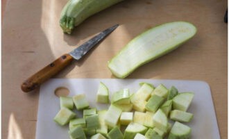 Hur lagar man läckert zucchini i en långsam spis? Vi tvättar och skalar grönsakerna, skär zucchinin i medelstora kuber.