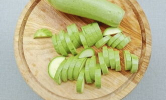 Tvätta zucchinin och skär i tunna halvcirklar.