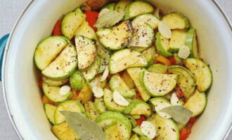 Vi kompletterar grönsakerna med vitlök och lagerblad. Strö över malen svartpeppar igen.