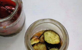 Ilagay ang mga pritong gulay sa mga layer ng pre-sterilized na garapon, pagdaragdag ng sarsa.