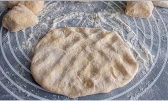 A nagyobb tésztadarabokat közepes vastagságú tortává nyújtjuk. A nagyobb tésztadarabokat közepes vastagságú tortává nyújtjuk.