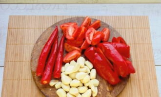Hugasan at tuyo namin ang mga ito. Balatan ang bawang at mainit na paminta, gupitin ang mga kamatis sa mga hiwa.