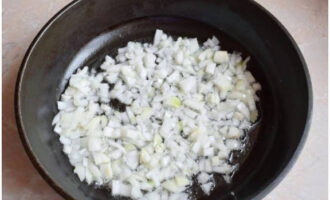Hacka löken och stek den i en stekpanna med vegetabilisk olja tills den är mjuk.
