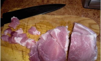 Hrișca cu carne într-un cuptor lent este foarte ușor de preparat. Clătiți carnea de porc cu apă rece și uscați cu prosoape de hârtie. Apoi tăiați carnea în cuburi nu foarte mari.
