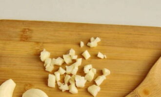 Gupitin ang mga clove ng bawang sa maliliit na cubes.