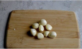 Hatiin ang ulo ng bawang sa mga clove, alisan ng balat ang mga ito. Banlawan.
