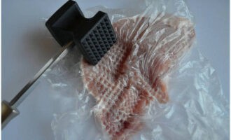 Puneți deasupra o pungă sau folie alimentară. Acest lucru se face pentru ca la batere sa nu pateze totul in jur. Folosind un ciocan de bucătărie.