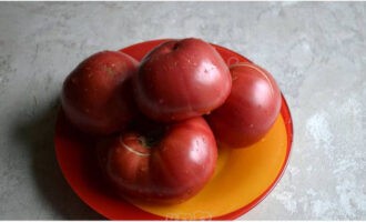 Hugasan namin ang mga hinog na kamatis, hatiin ang mga ito sa mga segment, at gupitin ang mga tangkay.