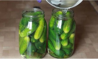 Giet het water uit de potten en giet de kokende marinade over de augurken. Voeg aan elk potje een theelepel essence toe.