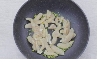 We wassen, drogen en snijden de kipfilet ook in blokjes, doen deze bij de gember en bakken snel op hoog vuur tot de kleur licht wordt.