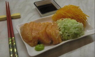 Đặt các mảnh rau củ bên cạnh các lát cá hồi. Thêm một ít wasabi vào món ăn và đổ nước sốt vào tô. Phục vụ sashimi cá hồi chế biến tại nhà ngay trên bàn và ăn bằng đũa. Chúc ngon miệng!