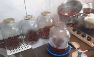 Vul vervolgens de kersen in de potten opnieuw met kokende siroop en sluit ze onmiddellijk af met deksels.