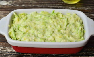 Grasa ang isang refractory pan na may langis at ipamahagi ang masa ng zucchini. Painitin muna ang oven sa pamamagitan ng pagtatakda nito sa 200°.
